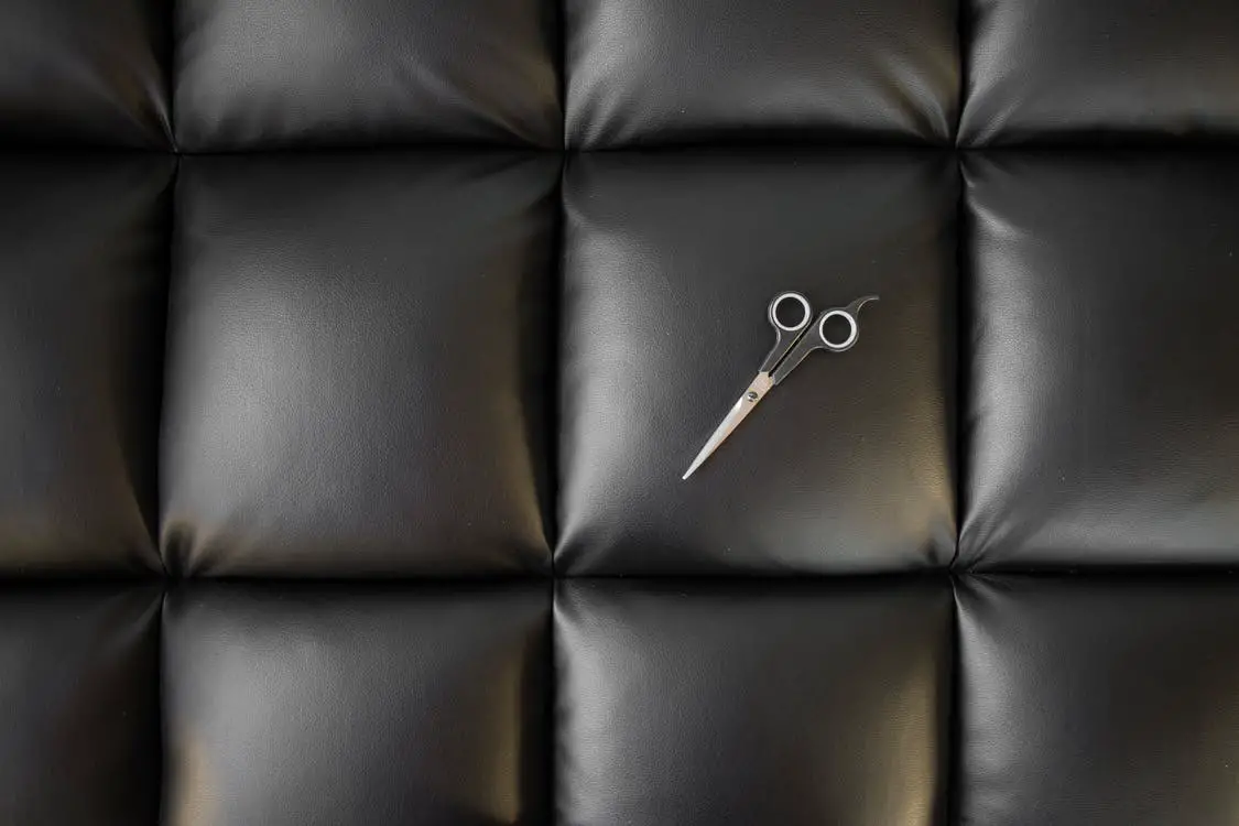 A pattern of a leather sofa with a pair of scissors on it