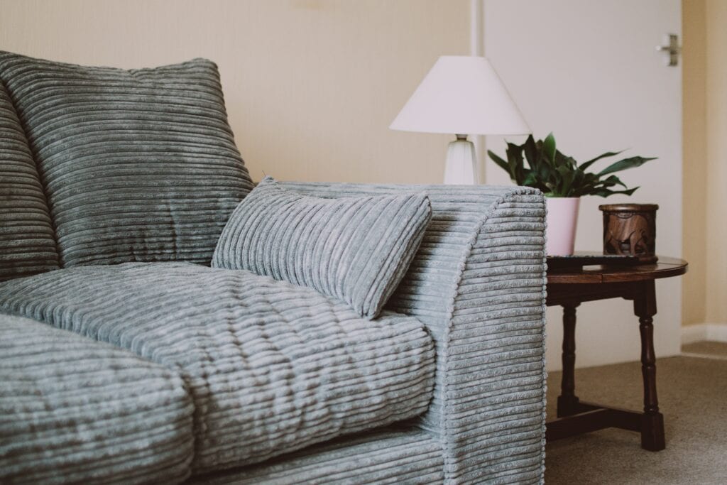 A gray sofa next to a lamp