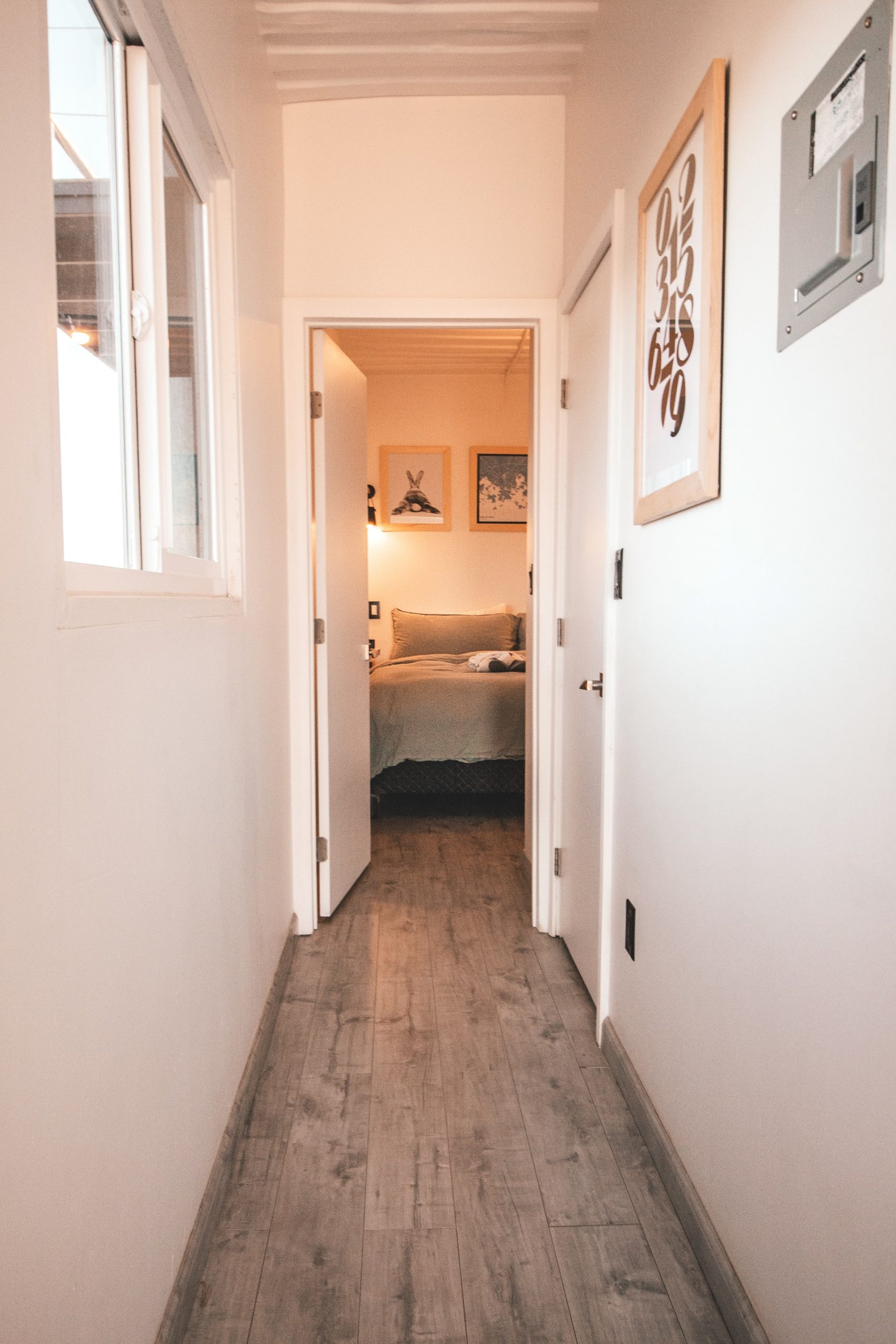 A laminate floor hallway leading to a bedroom